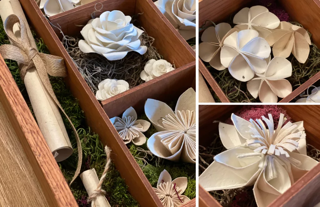 Close up images of origami flowers inside of a wooden box.