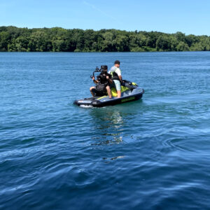 Behind the scenes of a commercial shoot. Cameraman on the back of a jetski.