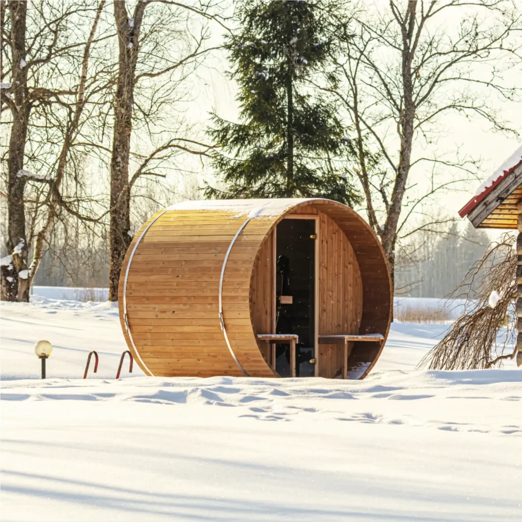 Barrel sauna sitting in a snow covered field
