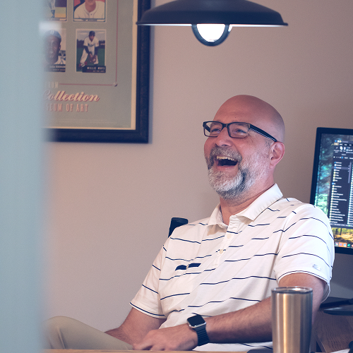 Man sitting relaxed in his office and laughing
