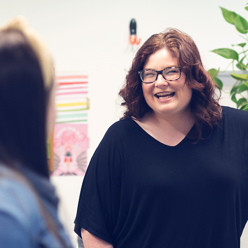 Woman laughing while looking toward another coworker