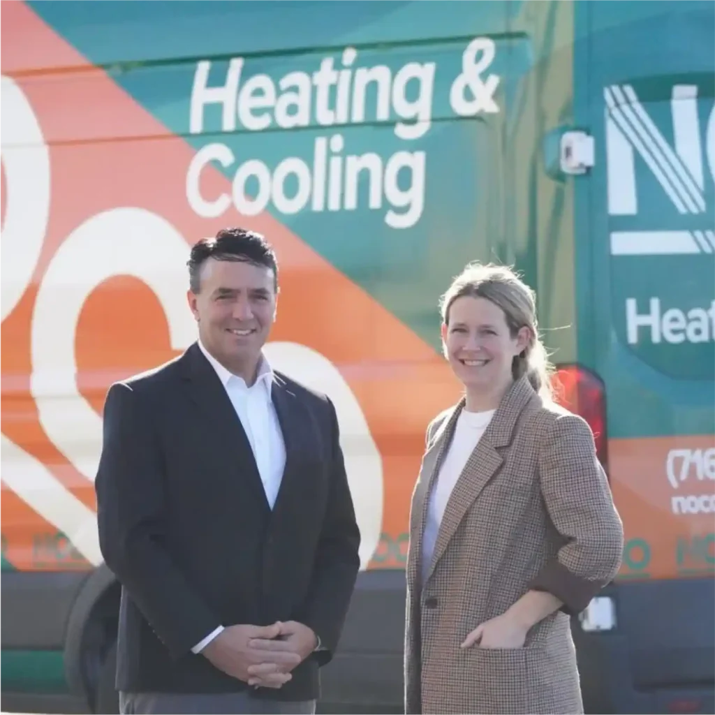Two business people standing in front of a business van.